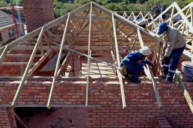 Roof truss installation progressing smartly - craftsman at work